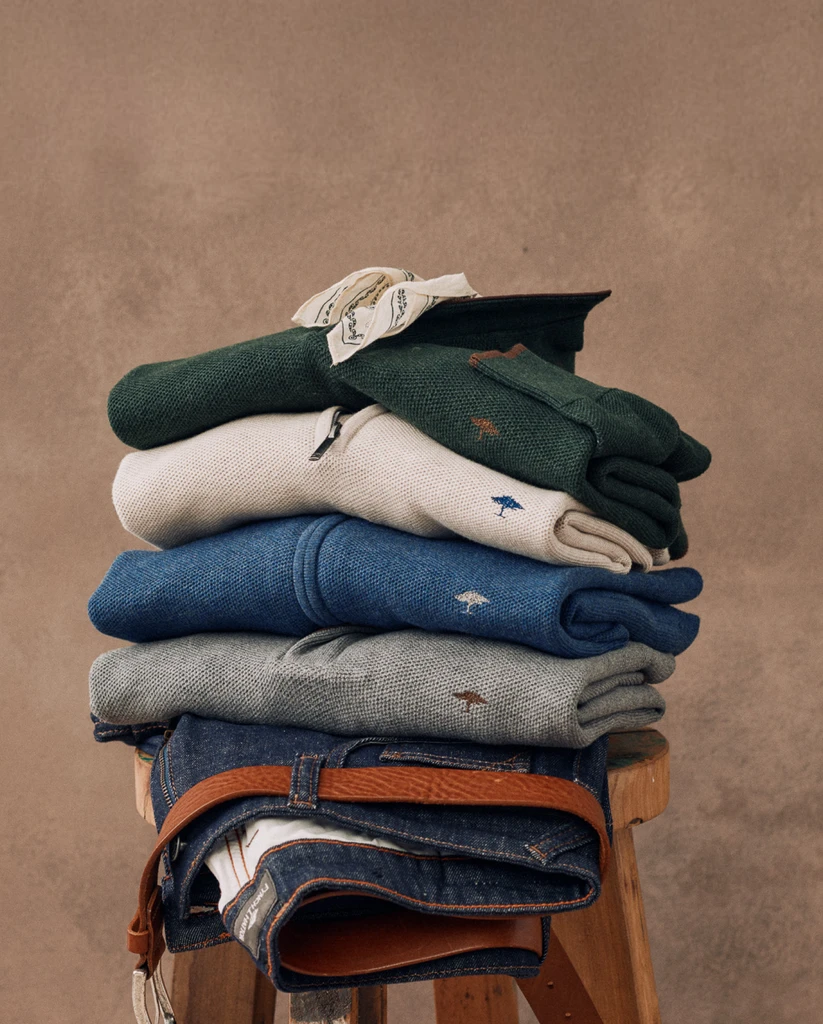 Fynch-Hatton knitwear stack photography on a wooden stool.
